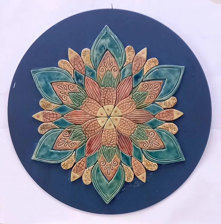 Rosace aux pétales turquoise, verts et roses sur un fond bleu